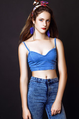 Studio photo of young woman on black background.