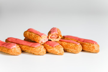 Pink icing Eclairs on white backgound 