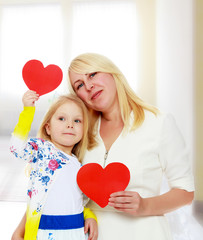 Mother and daughter holding a heart.