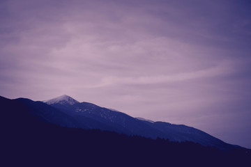 Fototapeta premium Photo depicting a beautiful moody frosty landscape European alpine mountains with snow peaks on a blue sky background.