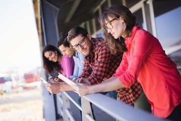 Business colleagues using tablet pc in balcony