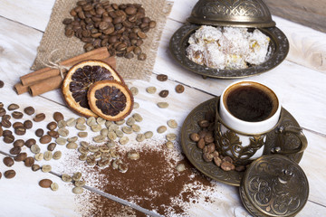 Turkish coffee with delight and traditional copper serving set on wooden