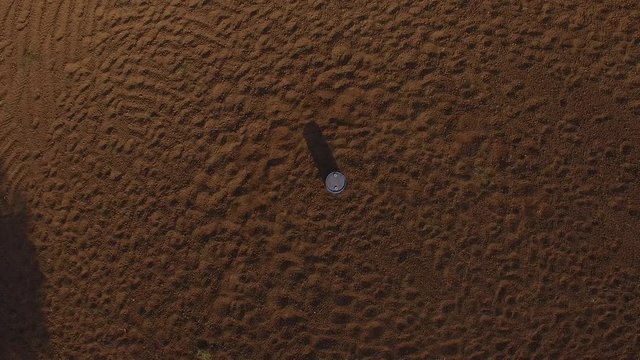 Overhead aerial shot of woman riding horse around barrel