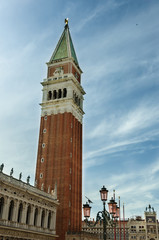 Fototapeta na wymiar Close view of St Mark's Campanile, St Theodore of Amasea statue and Biblioteca in Venice, Italy.