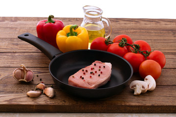 Raw pork meat with spices and vegetables on wooden desk close up, top view, horizontal