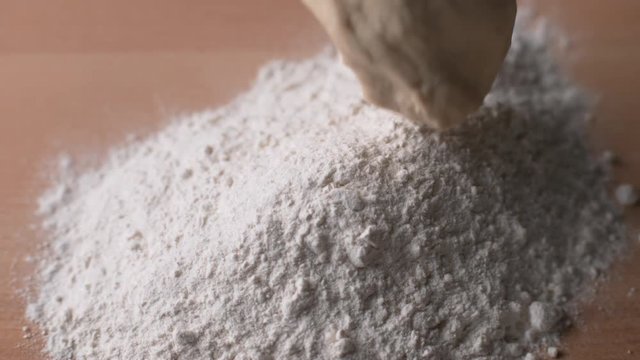 Bread dough falling onto flour in super slow motion