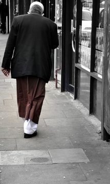 Rear view of man walking on sidewalk
