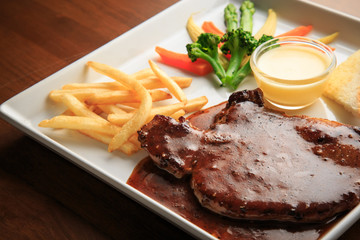 Grilled pork with barbecue sauce and vegetables salad sauce on white dish wooden background