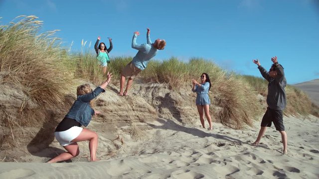 Super slow motion shot of guy doing backflip at beach with friends, shot with Phantom Flex 