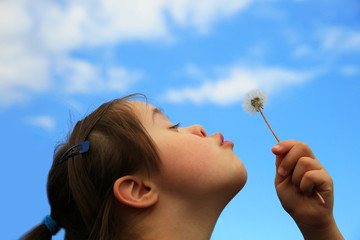 Little girl blowing dandelion