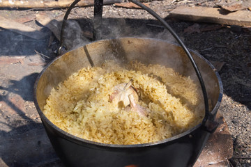 Pilau in cauldron on fire
