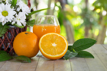 Fresh oranges and juice in glass on gray cloth and old wooden wall / Selective focus and Still life image.
