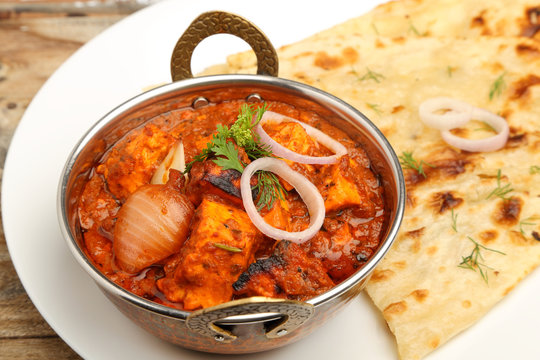 Indian Food or Indian Curry in a copper brass serving bowl with bread or roti.