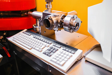 Fragment of a laboratory or plant with a metal pipe and computer keyboard