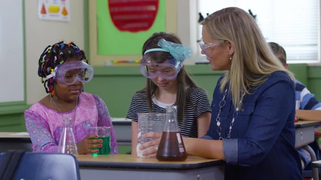 Teacher and students doing science experiment in school classroom