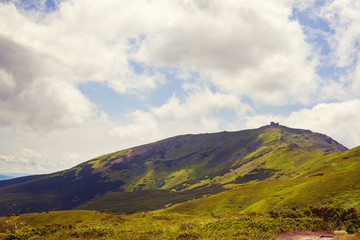 Silhouette of a mountain observatory on top of a green ridge