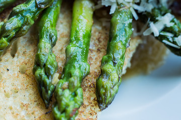 Fresh asparagus with bread and parmiggiano cheese, detail. Macro. Horizontal. Gourmet style.