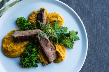 Gourmet duck and turmeric vegetables cream.  Top view, white plate.