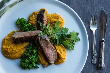 Gourmet duck and turmeric vegetables cream.  Top view, white plate.