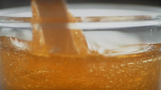 Stick mix honey in a jar. Close up. Sugaring