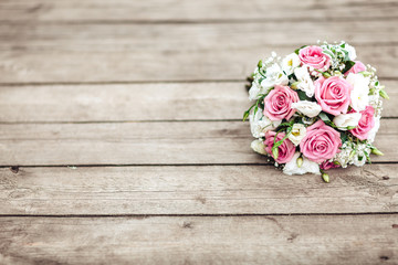 A bridal bouquet of a bride from white and pink roses lies on a wooden background, horizontally