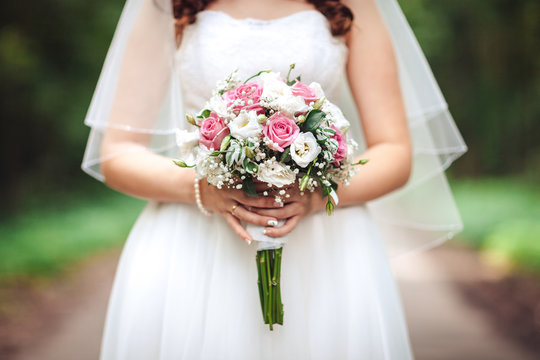 Bride holding a wedding bouquet, close-up, natural background
