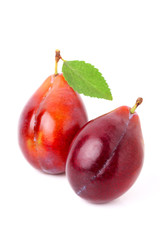 Two ripe red plum with leaf isolated.