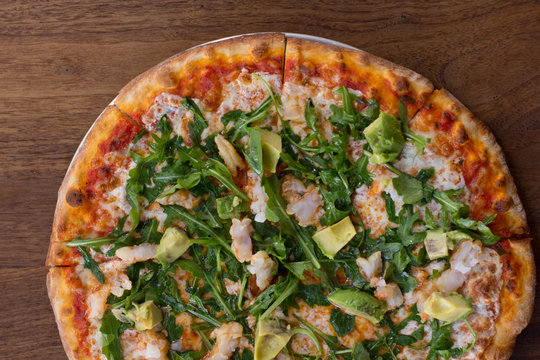 Brick Oven Pizza topped with arugula, shrimp, avocado, and lime
