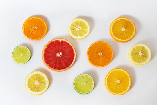 cut citrus slices orange, grapefruit, lemon, lime, tangerine on a white background filled with water
