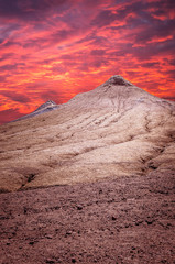 Sunset over muddy volcanoes, Buzau county, Romania. Active mud volcanoes landscape in Europe.