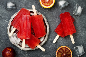 Homemade frozen blood orange natural juice alcoholic popsicles - paletas - ice pops. Overhead, flat...