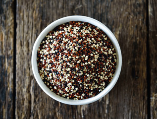Quinoa seeds in bowl on wood