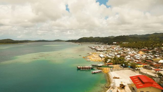 Cargo and passenger port with barges and cargo ships on tropical island. Aerial view:passenger ferry terminal Dapa city .Ferries for transport vehicles and passengers in the port. Philippines, Siargao