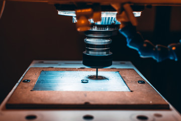 Close-up view of CNC milling machine cutting work piece of aluminum with high rotation speed in...