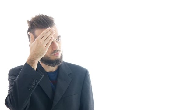 Serious bearded man in suit tapping on his forehead, business nonsense and stupidity concept, studio isolated on white background.
