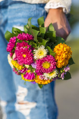 Young woman holding a bouquet of flowers in his hand outside