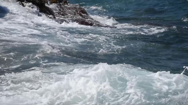 Sea waves breaking on rocky seashore