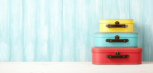 Travel concept with retro style suitcases on blue wooden background