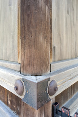 Traditional Japanese woodworking mitered butt joint supported by metallic pins and sheets at corner of an ancient building in Japan