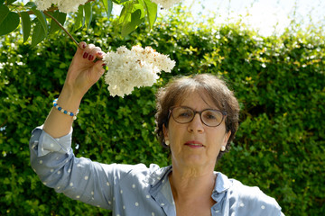 Obraz premium senior woman in her garden with flowers