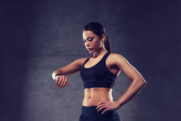 young woman with heart-rate watch in gym