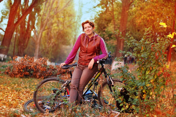 Fototapeta na wymiar Autumn Park. Woman enjoys riding