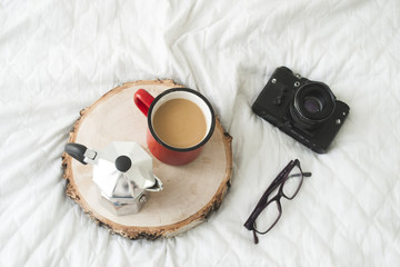 Blogger workspace with retro camera, glasses, and coffee cup and kettle on wooden table