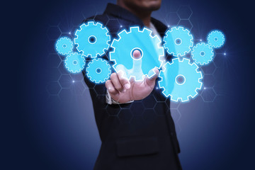 Businessman touching modern technology interface with gear wheel setting