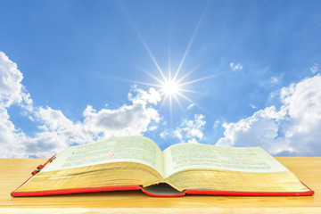 Open bible with sun and blue sky