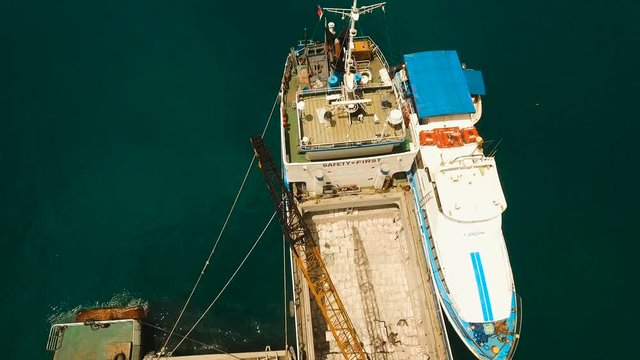 Cargo and passenger port with barges and cargo ships on tropical island. Aerial view:passenger ferry terminal Dapa city .Ferries for transport vehicles and passengers in the port. Philippines, Siargao