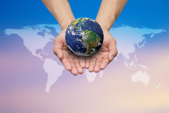 Two hands holding the earth on blurred map for safe and healing world concept.Elements of this image furnished by NASA.