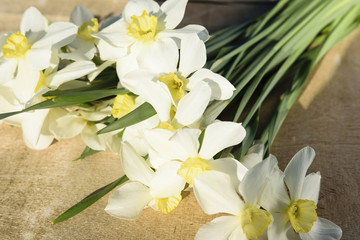 A bouquet of daffodils lies on a wooden background