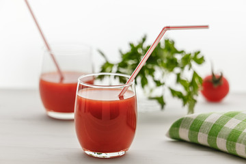 A drink of red color in the glass, and parsley on a white background.