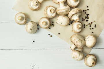 Fresh organic farm mushrooms and bell pepper on a white wooden background, top view. Place for the text.
